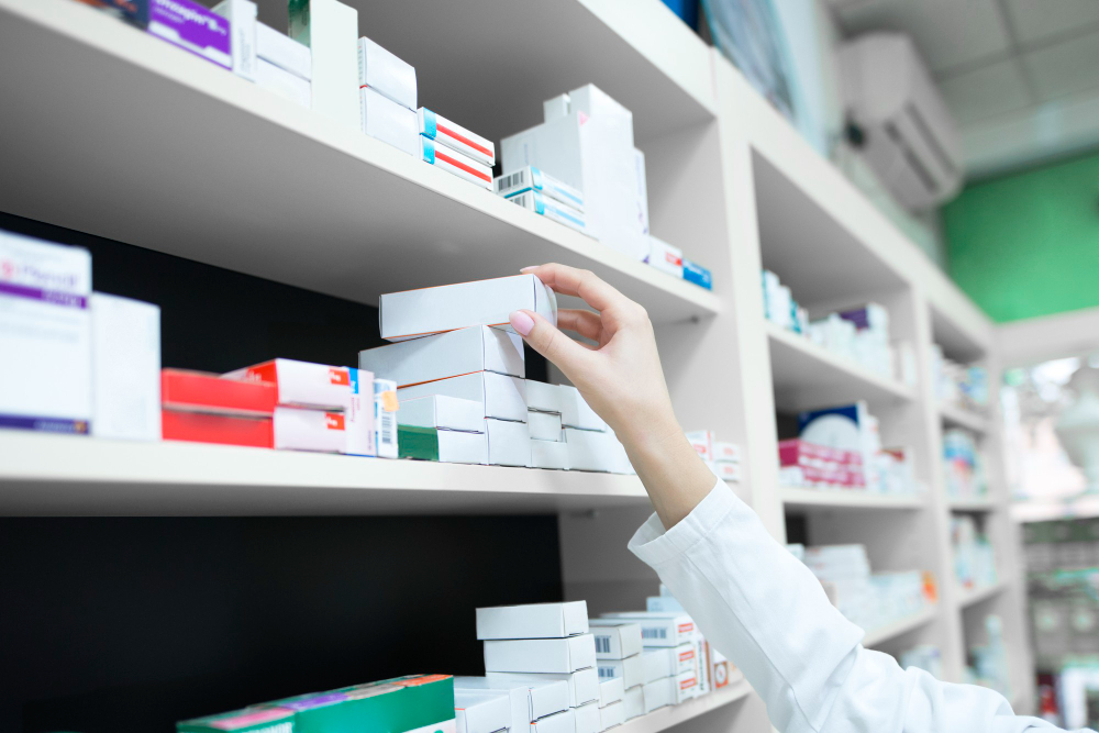vista-cerca-mano-farmaceutico-tomando-caja-medicina-estante-farmacia